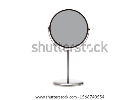 Cosmetic mirror in a metal frame on a stand