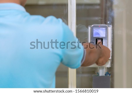 The hand are scanning on fingerprint machine for enter digital security door system in the office building at Bangkok ,Thailand.  Fingerscan with access control on the glass door. Royalty-Free Stock Photo #1566810019