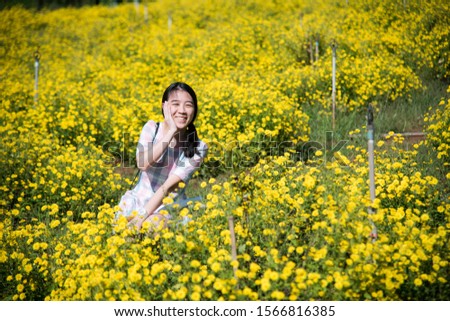 Pretty girl enjoying in a field with field flowers and smiles sincerely, Copy space