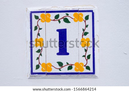 Number one painted in porcelain with some yellow flower and green leaves