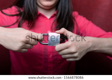 close-up photograph of an iron castle; iron lock in hands
girls, girl trying to open the lock with her own hands