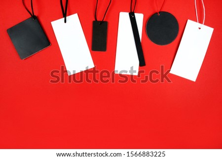 Flat lay with white and black price tags isolated on red. Black friday concept.