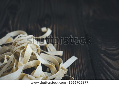 Detail of pasta tagliatelle on a wooden background