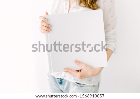 White book mockup. Square empty book. Album with clean pages in hands of woman. Clean book cover mockup