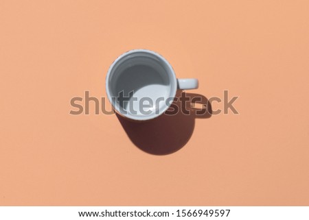 Empty tea cup on beige paper background. Coffee mug from above. Minimal concept Hard deep shadow. Flat lay, top view Royalty-Free Stock Photo #1566949597