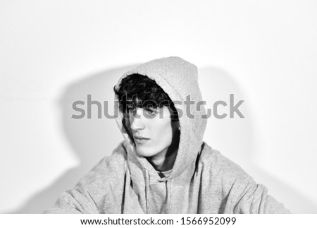 black and white portrait photography.young expressive handsome Italian teenager model boy posing for fashion shooting and wearing a hood
