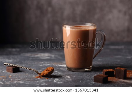 A delicious, natural cocoa drink with grated chocolate and milk in a glass mug is a source of vitamins and energy.