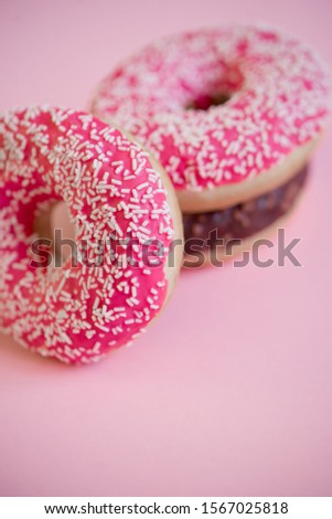 Donuts on a pink background.Tasty and delicious donuts with different icing and filling on a colored background.