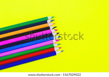 color pencils on a yellow background, background for designers, space for text