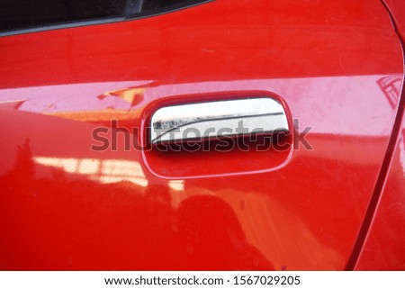 Close-up handle of a red car door. 