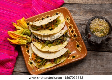 Traditional mexican quesadillas with squash blossom on wooden background