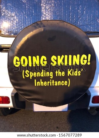 Going SKIing (Spending the Kids Inheritance) spare tyre cover on the back of a white car