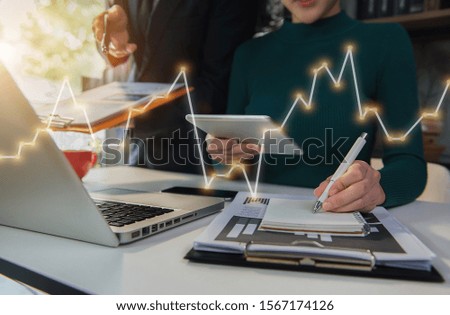 Businessmen or financial data analysts working with tablets and laptop computers and data graphs together. Plan to analyze projects in the office.
