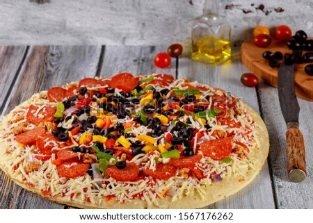 Round pizza with pepperoni, sausage, olives, pepper, onion and cheese.