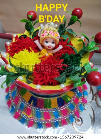 Greeting card: a showpiece of a cute chirping doll placed on a well-decorated pot