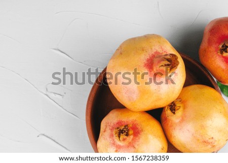 Ripe pomegranates on a light gray kitchen table
