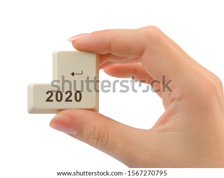 Computer button 2020 in hand isolated on white background
