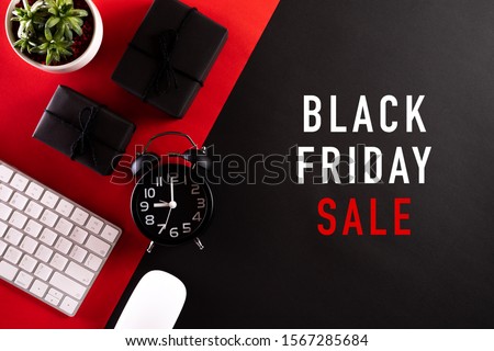 Black Friday Sale text with Alarm clock, keyboard mouse, gift box on red and black background. Online Shopping concept and black Friday composition.