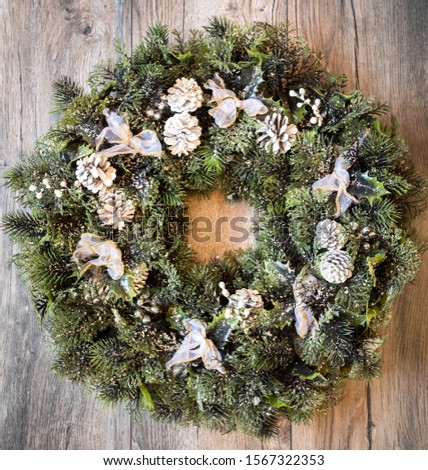 Christmas wreath with frozen pine cones and pines.Top View.  Advent reef with christmas theme on wooden background.