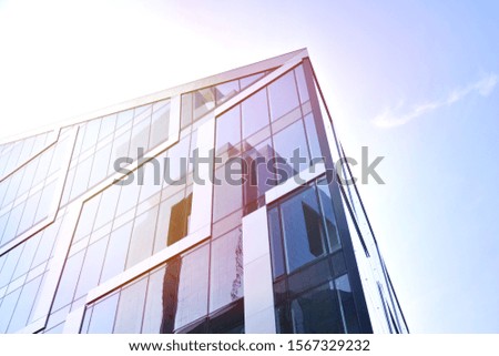 Modern office building detail, glass surface with sunlight.