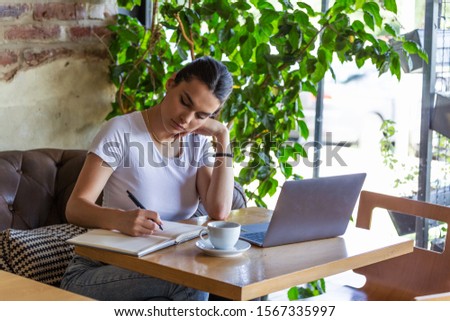 Young business woman is working in a cafeteria in her break. Student studying from coffee shop. Enjoying work from coffee shop. Doing Business From coffee shop