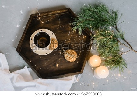 Tray for breakfast with a mug of tea cookies and a candle of rom