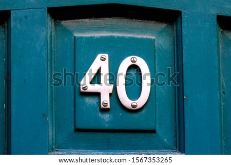 House number 40 in silver metal digits on a wooden front door