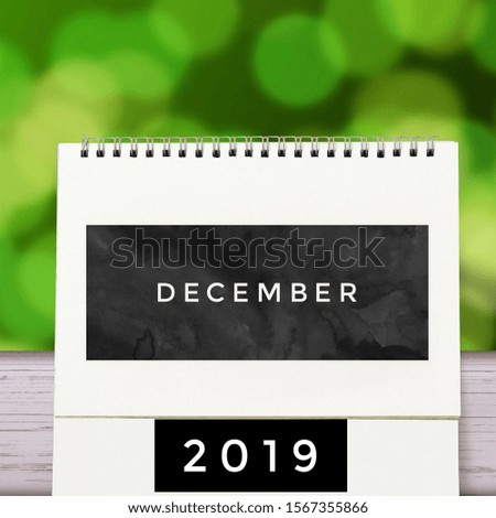 Simple 2019 December monthly calendar on table with office supplies. December month 2019 Spiral Calender with green abstract.