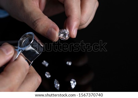 Jeweller checking diamond. Loose diamonds. Cut and polished diamonds. Hand with diamond. Diamond expert examining diamonds. Royalty-Free Stock Photo #1567370740