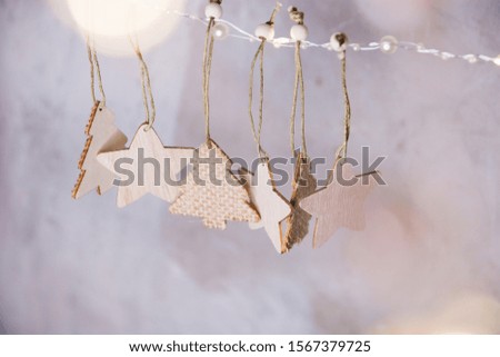 Festive background, Christmas and new year decorations wooden Christmas trees and stars hanging on a rope flat lying on a gray background