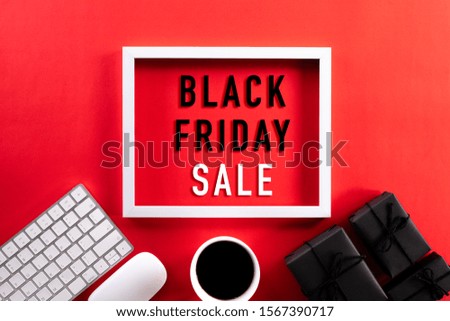 White picture frame with keyboard mouse coffee cup, gift box and Christmas tree decoration on red background. Online Shopping concept and black Friday composition.