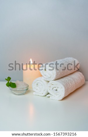 SPA&Recreation concept photo with candle, stack of towels and sea salt for bath, vertical orientation.