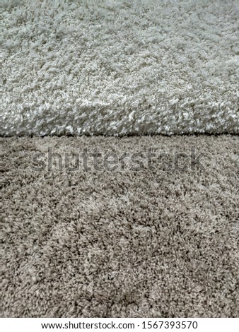 Multiple colorful soft warm rug carpets or fluffy blankets rolled and stacked as sample in the carpet shop industry for interior cozy design