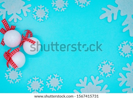 Christmas or winter composition of white balls and snowflakes on a blue background. Christmas, winter, new year concept. Flat lay, top view, copy space
