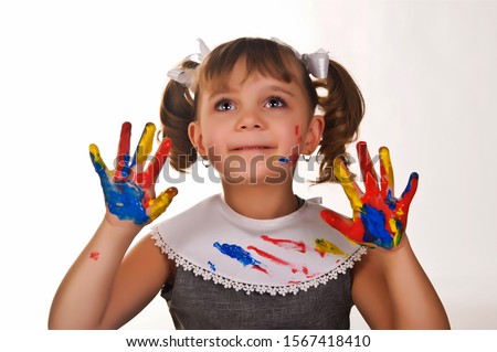 Little girl with hands covered in finger paint after painting a picture
