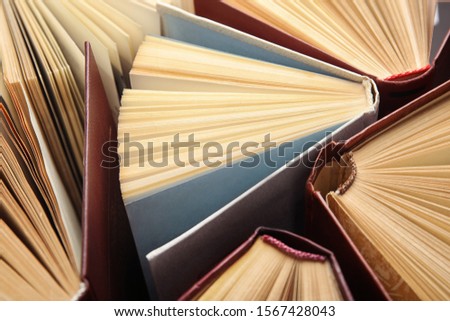 Many different hardcover books as background, closeup