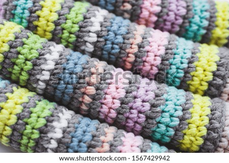 Women's hobby. Crochet and knitting. Knitted striped details on white background.
