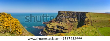 Cliffs along the Causeway Coastal Way on the coast of Northern Ireland on a bright and sunny day.