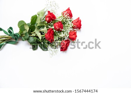 Beautiful bouquet of red roses and baby's breath white flowers isolated on a white background with copy space. Horizontal. Top view.