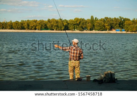 fisherman get a perch with rod and reel, horizon image.