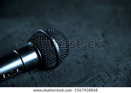 Black microphone dropped to the black wooden floor.Musical instrument for singing and karaoke.