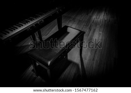 small grand piano in dark room black and white