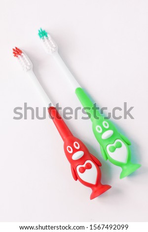 Cute kids toothbrushes in a shape of penguins on a white background isolated. Funny teaching children to easy brush teeth. Social media banner. Dental and healthcare concept. Free copy space.