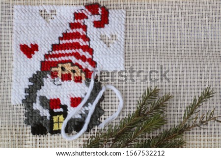 Unfinished Christmas cross stitch designs and spruce decorations. Preparing handmade gifts for New Year and Christmas at home. Flat lay, top view