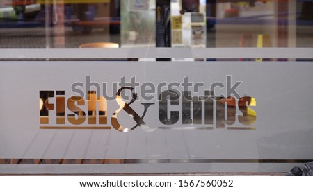 fish and chips sign etched on glass window Royalty-Free Stock Photo #1567560052