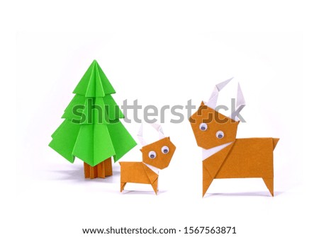 Origami Christmas paper art : Reindeer and Christmas tree for greeting season of Christmas and New year. Copy space