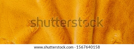 Fashionable yellow colored fur texture, banner. Decorative dyed sheepskin. Yellow fluffy fur, fast fashion background. 
