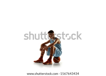 Full length portrait of young basketball player with a ball isolated on white studio background. Teenager confident posing with ball. Concept of sport, movement, healthy lifestyle, ad, action, motion.