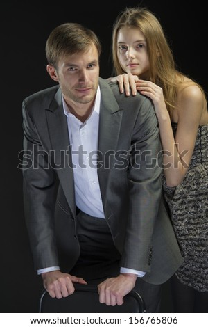 portrait of a beautiful pair of men and women posing for the camera in a studio on a black background