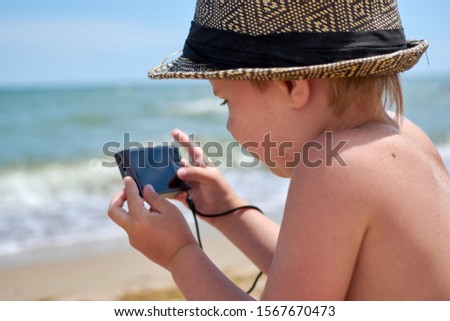 boy with a camera by the sea
